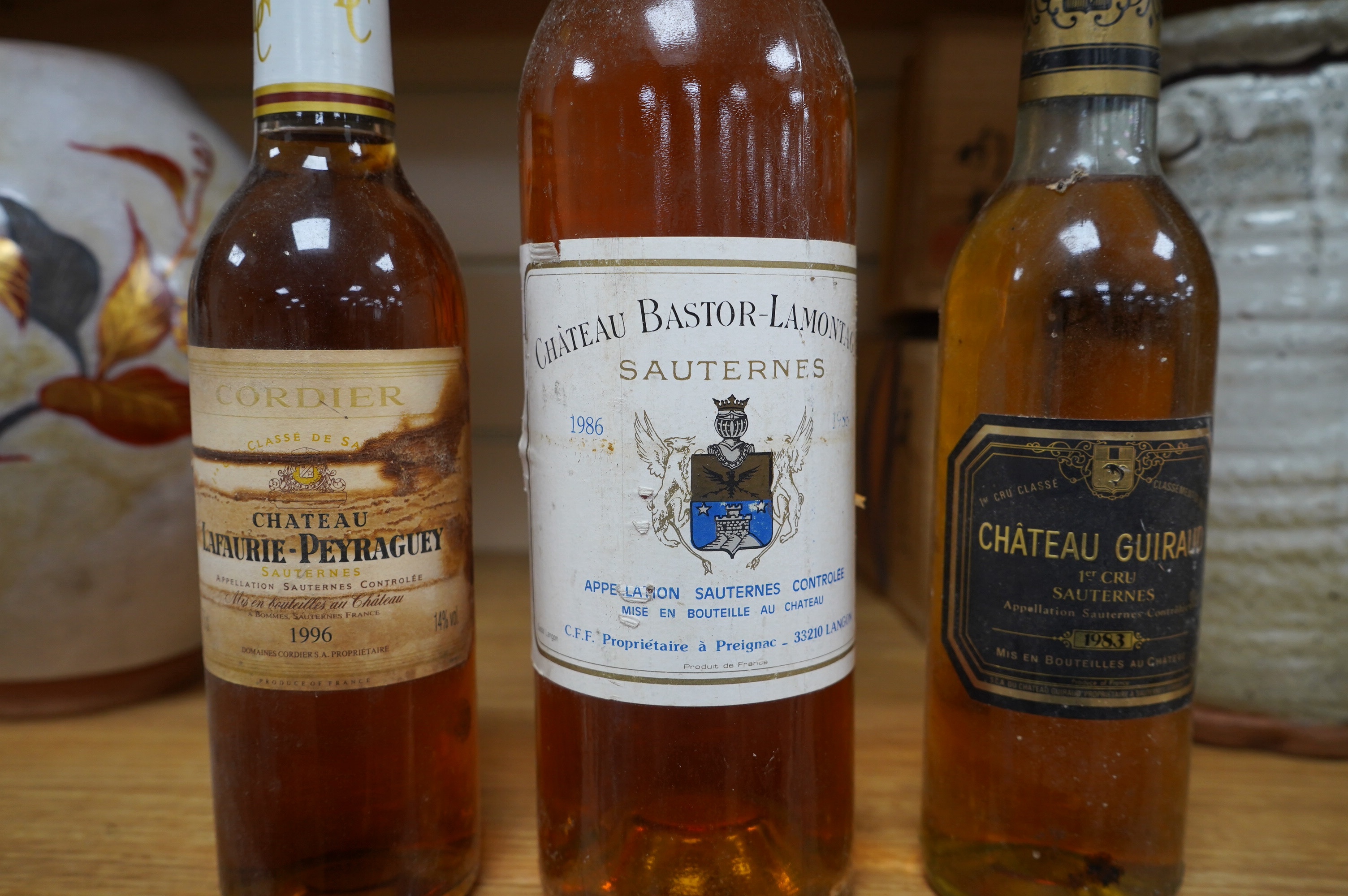 Wine: a bottle of French Sauternes and two half bottles comprising a bottle of Chateau Bastor - Lamontagne 1986, a half bottle of Chateau Guiraud Ist Cru 1983 with another half bottle of Chateau Lafaurie - Peyraguey 1996